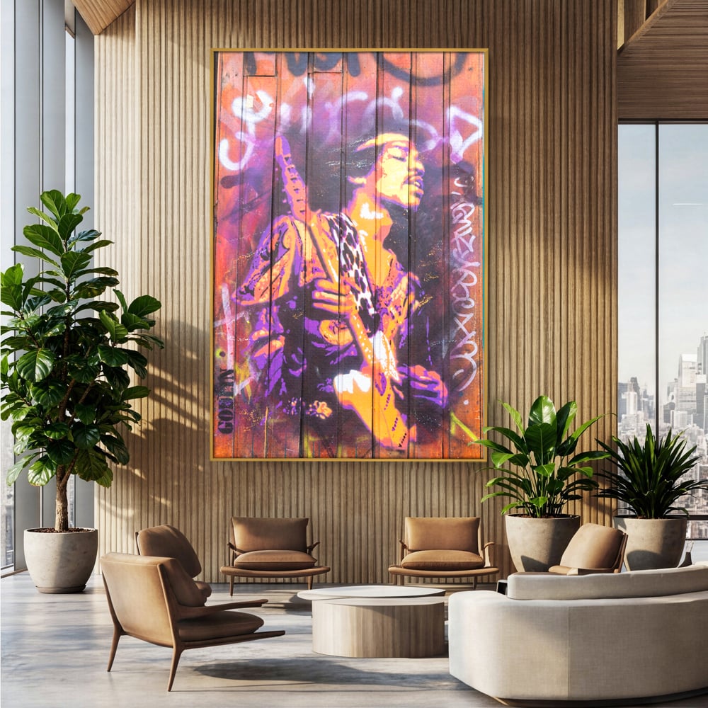 Tablou canvas cu tablou canvas cu jimi hendrix cantand la chitara, in rama de aluminiu auriu, pe perete intr-un birou
